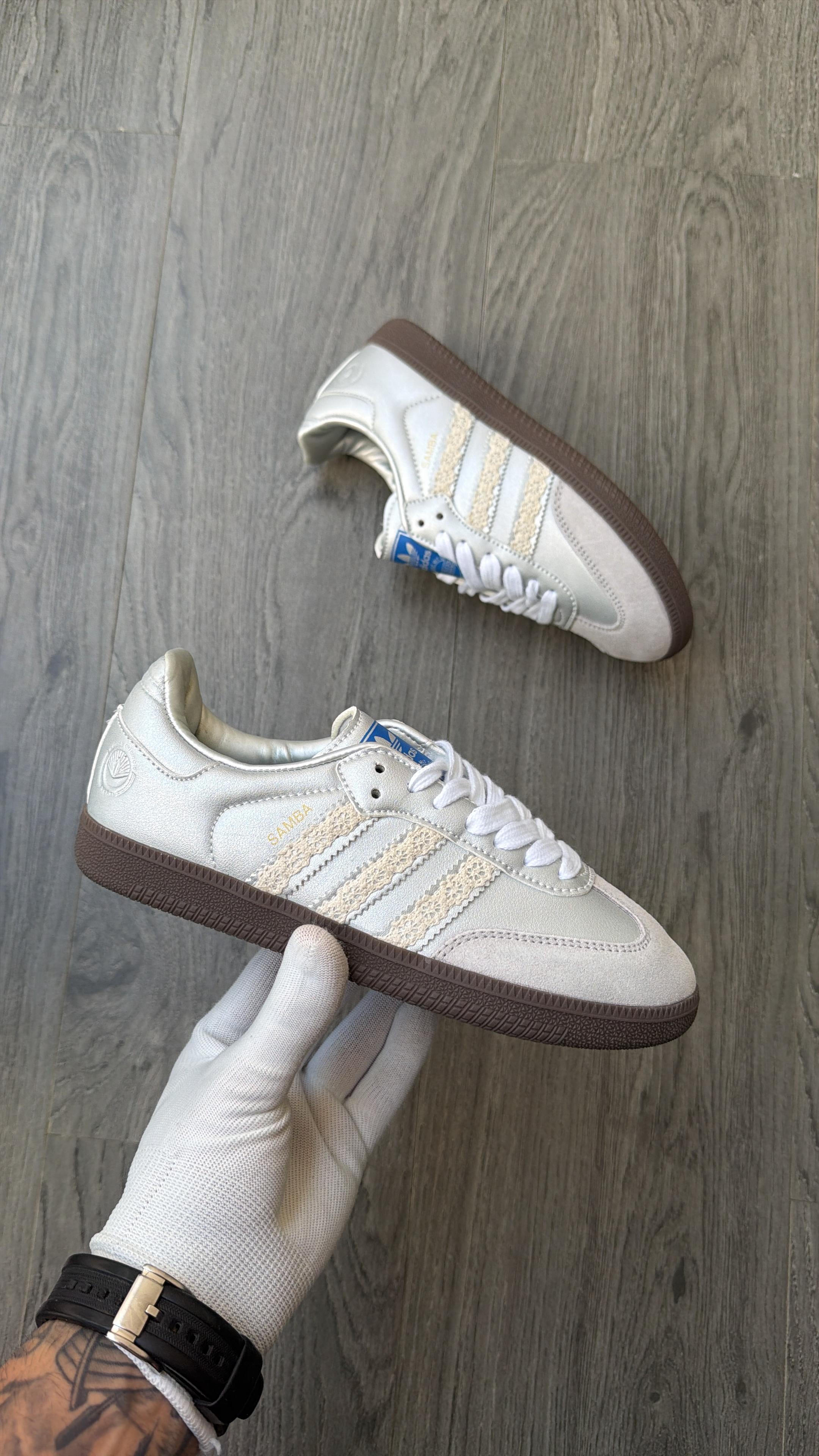 Adidas samba silver leather upper, textured signature 3-stripes, and a dark brown