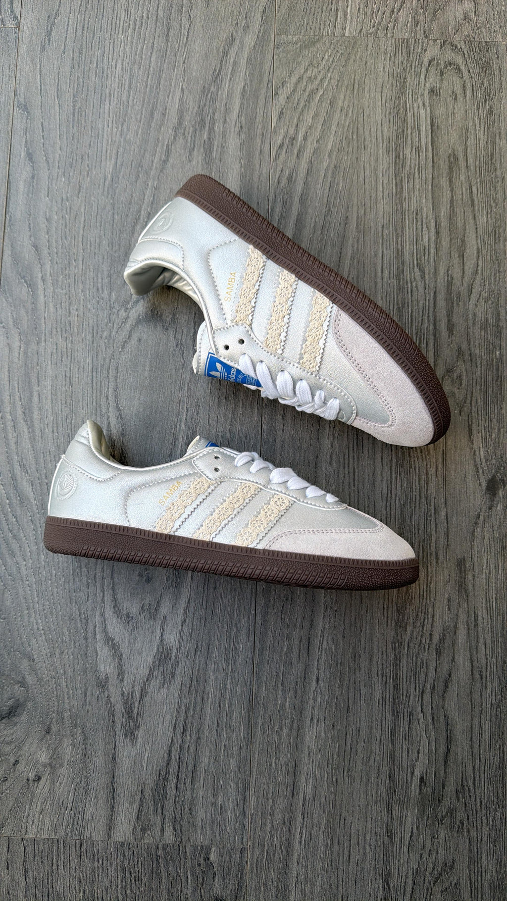 Adidas samba silver leather upper, textured signature 3-stripes, and a dark brown